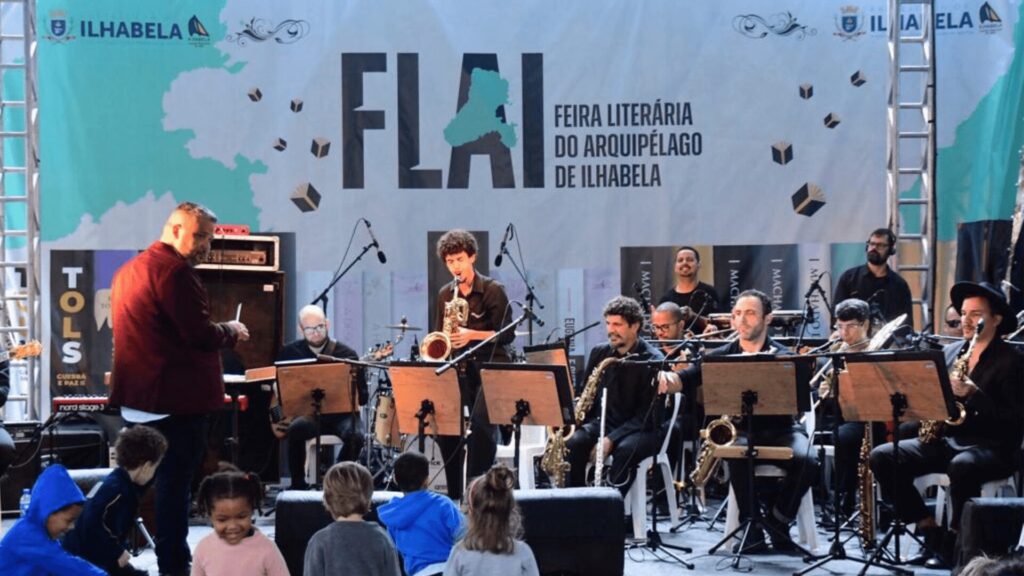 Orquestra tocando no palco para uma multidão.