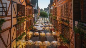 Rua estreita e charmosa, ladeada por edifícios com estrutura de madeira, adornados com guarda-sóis decorados e luzes quentes, criando uma atmosfera aconchegante.